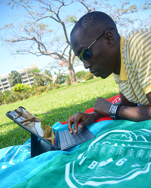 Chris Smith a.k.a. CLS, laying on a blanket at the park getting some work done with an iPad Pro and Logitech Slim Folio Pro accessory during it's launch campaign.