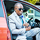 Chris Smith a.k.a. CLS, exiting vehicle wearing a dapper suit in an Instagram post.