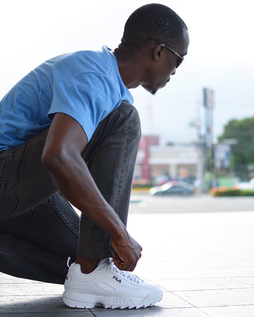 Chris Smith a.k.a. CLS, wearing the Fila Disruptor 2 Sneakers on the mall during the Fila Disruptor 2 Social Media Campaign.