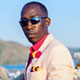 Chris Smith a.k.a. CLS, wearing a blazer and colourful outfit in an Instagram post.